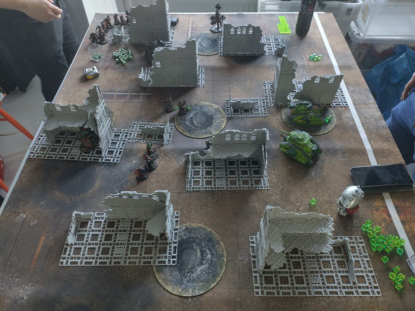 Tabletop wargame setup with miniature figures and terrain on a table.